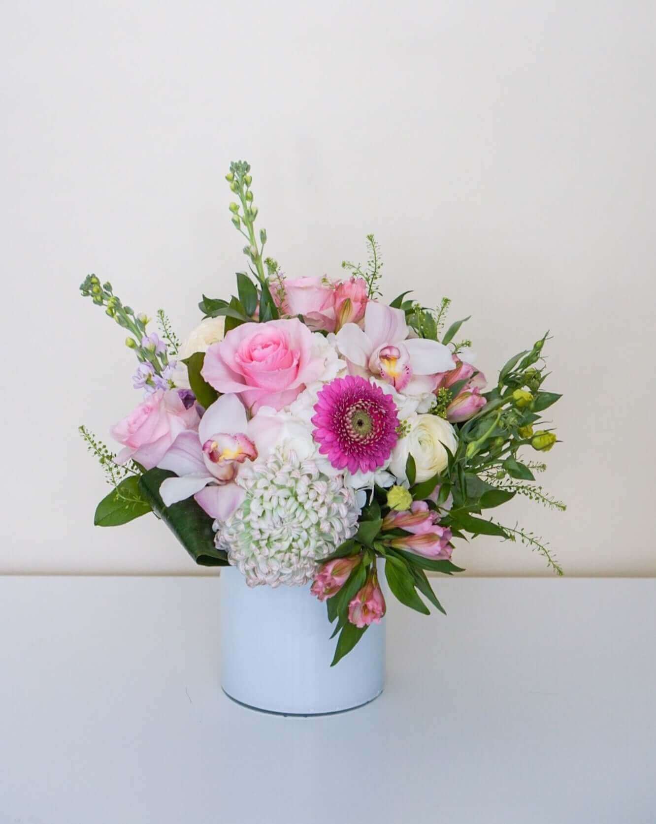 Divine pretty pastels artfully styled in our white glass vases. Approx. Overall Dimensions: 10"L x 10"H. Base Dimensions: Standard - 4.25" x 6.75". Premium 7.5" x 7.5"