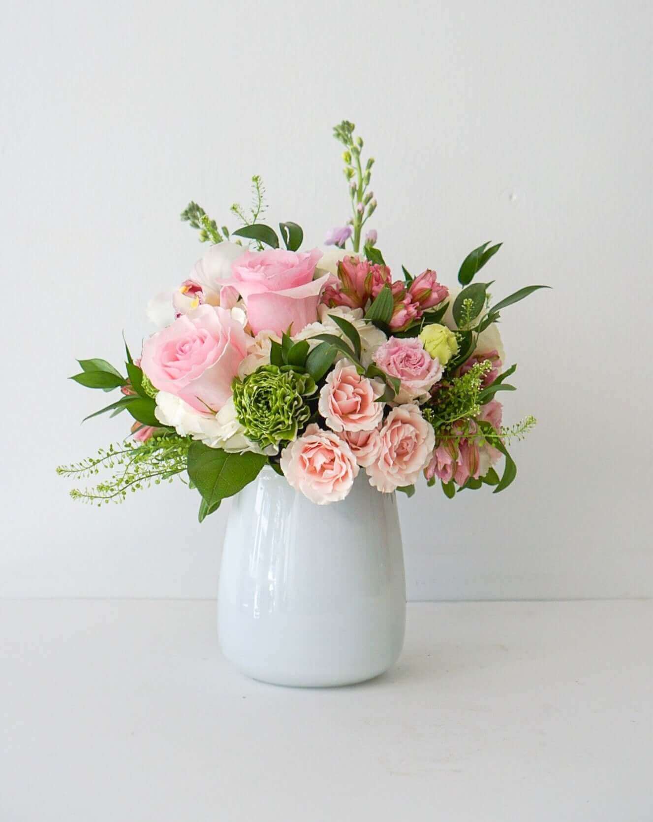 Divine pretty pastels artfully styled in our white glass vases. Approx. Overall Dimensions: 10"L x 10"H. Base Dimensions: Standard - 4.25" x 6.75". Premium 7.5" x 7.5"