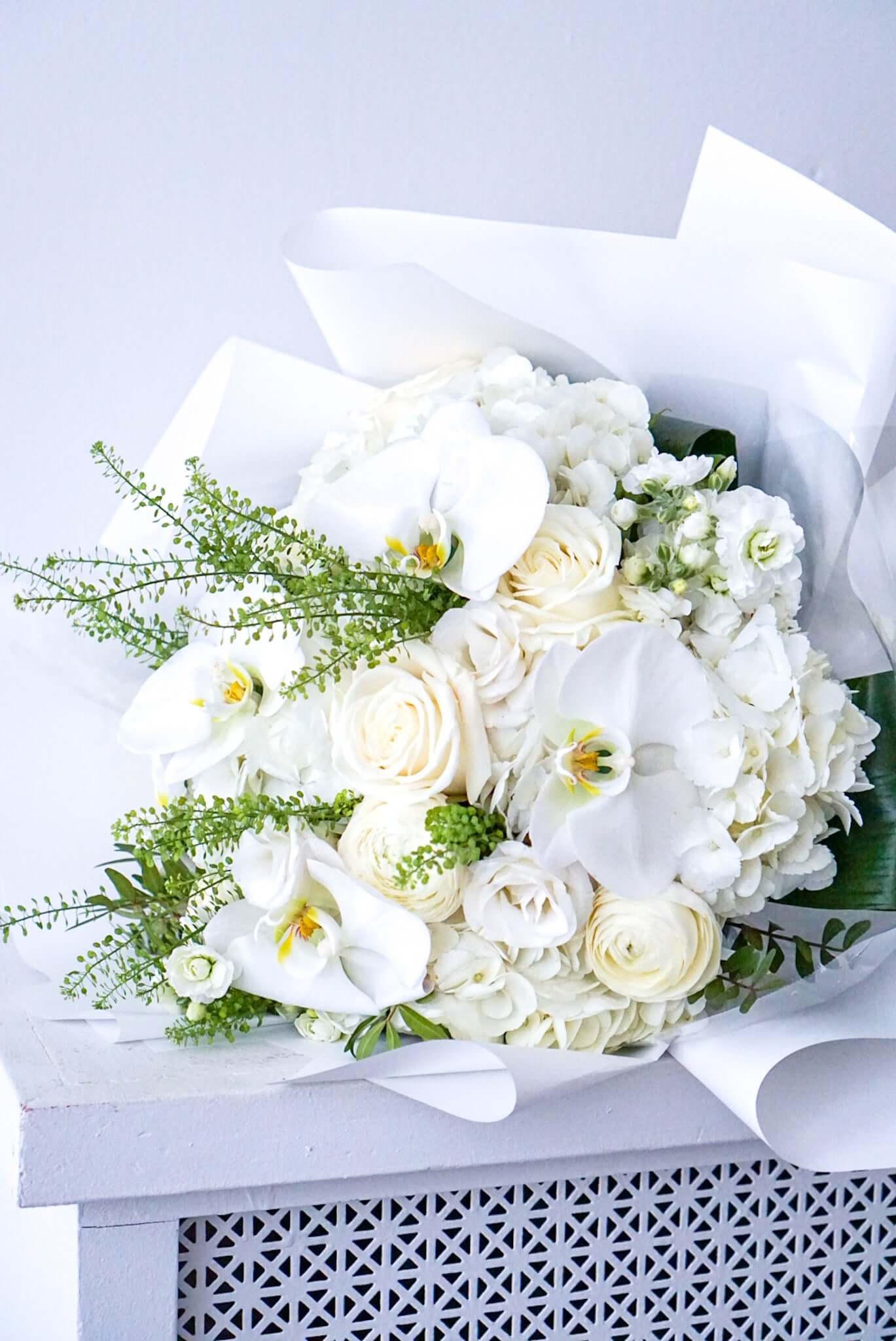 Turn on the charm with this elegant white and cream bouquet. The flowers are gift wrapped and package in water to last for the day.