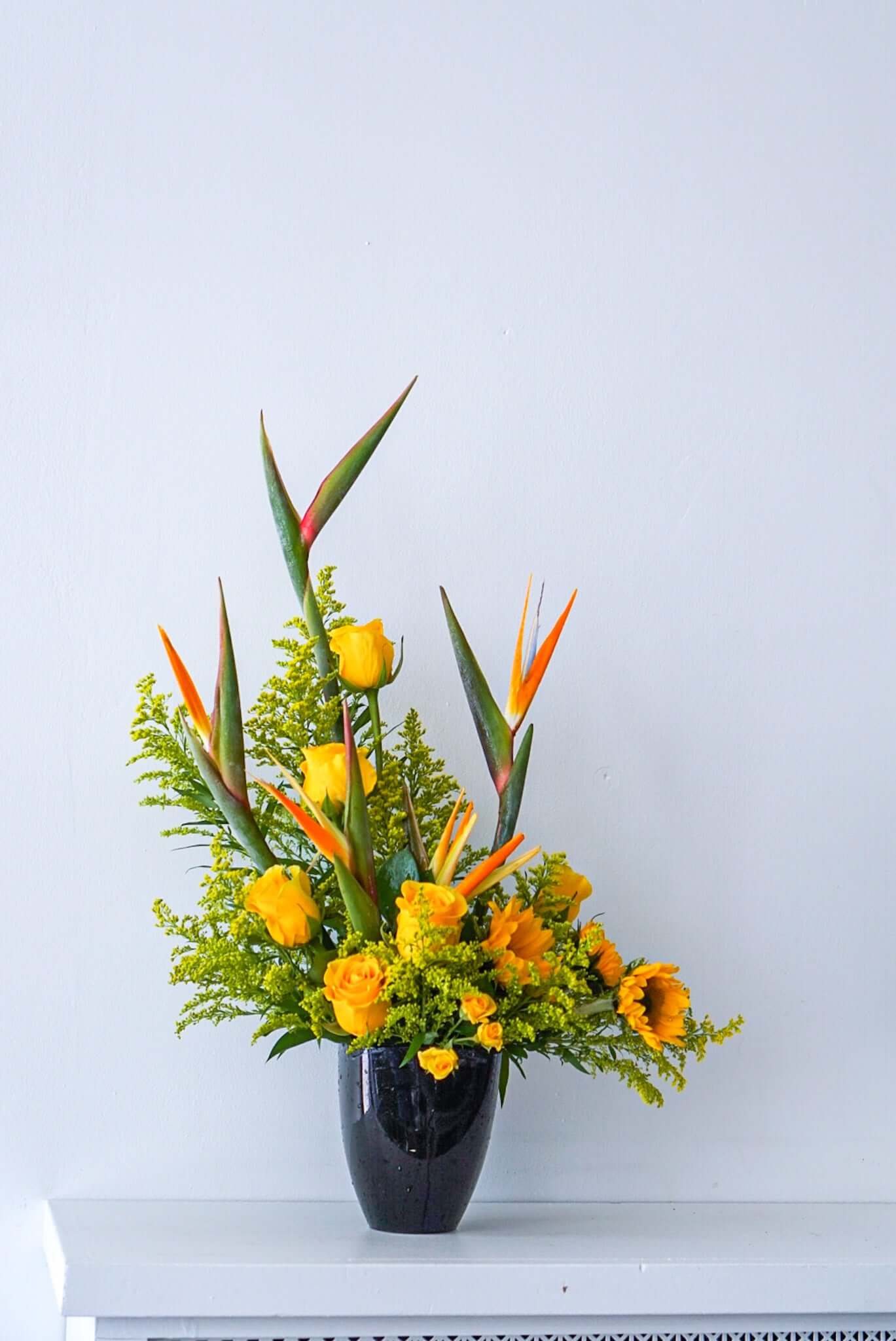 Send sun and paradise someone's way with this striking arrangement. We offer same-day and next-day delivery through out Toronto and GTA. This arrangement features Birds of Paradise, Sun flowers, Yellow Roses, Yellow Solidago