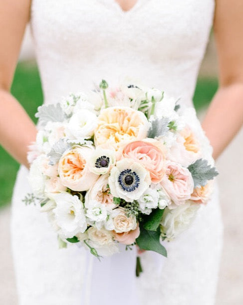 The classic, rounded bridal bouquet will always be a desired look. Full and lush , this bouquet is best suited to a bride wearing a classic ballgown with an elegant, romantic, timeless sense of style. The Flower Nook designs with a combination of ruffled blooms mixed with textured fillers, different sized and shaped flowers, and some space and movement between the layers of the bouquet, you can achieve a much more modern take on the classic, rounded bridal bouquet.- The Flower Nook - Toronto Florist