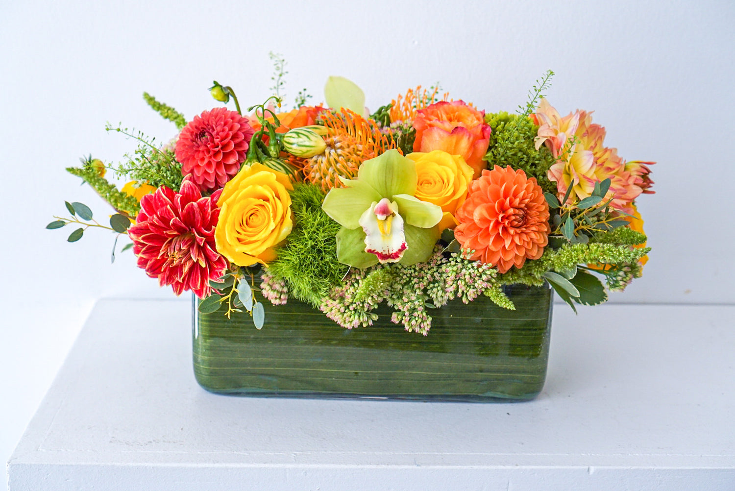 Harvest Centrepiece - Make fall shimmer with this glorious assorted of autumnal blooms, arranged in a modern rectangular vase.