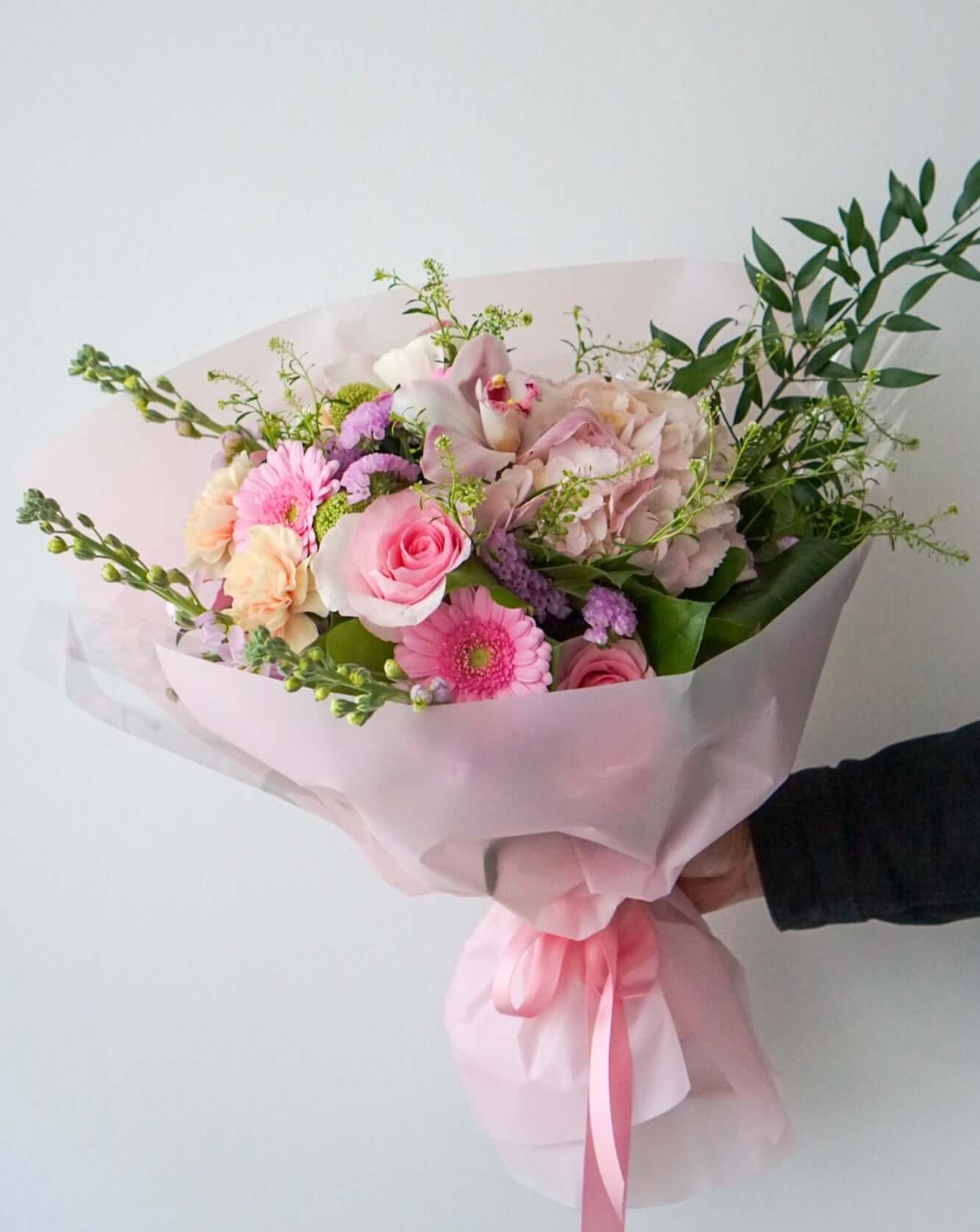 Divine pretty pinks artfully styled as a hand-tied bouquet and will be wrapped in tissue paper and cellophane, and the stems will be placed in a water bag.
