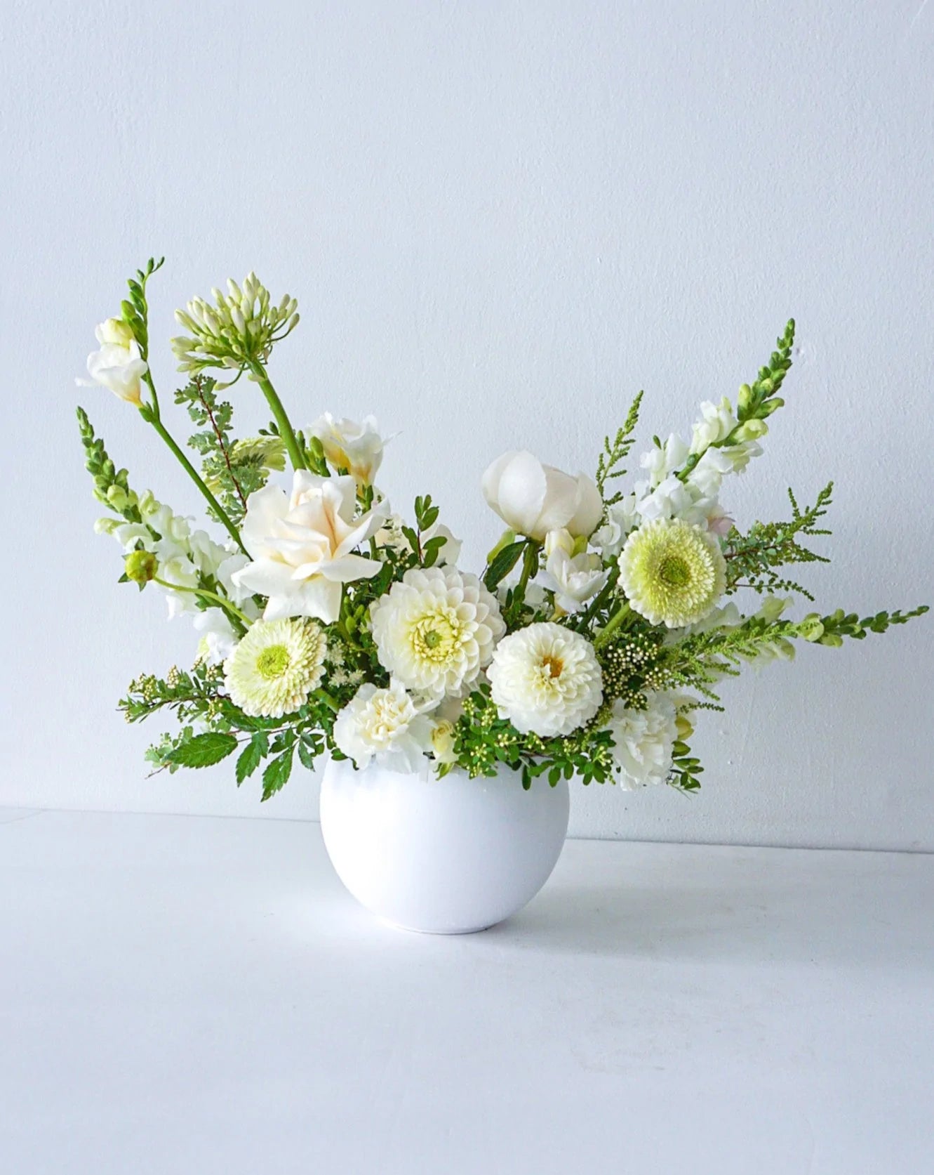 A stylish array of the seasons best crisp white and cream blooms in white bowl - an elegant gift for any occasion. We offer same-day or next-day delivery thought out Toronto and GTA. Toronto  Flower Delivery- The Flower Nook- Toronto Florist 