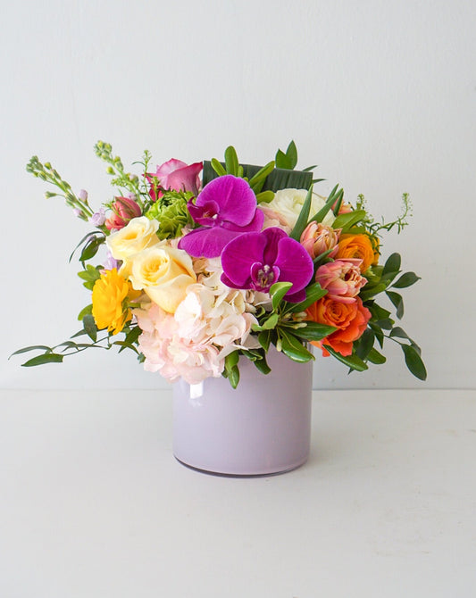 A selection of colourful spring blooms styled in our pink glass vases.