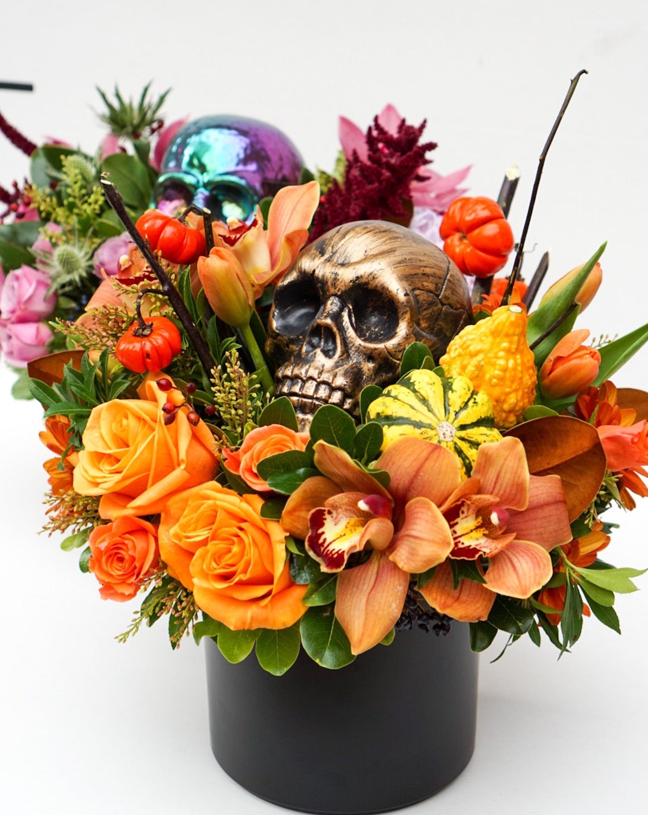 This Halloween flower arrangement is the perfect balance of scary and classy as it incorporates elements of Halloween, hence the skull, but also happy elements such as mini pumpkins, roses, orchids, celosia, etc.