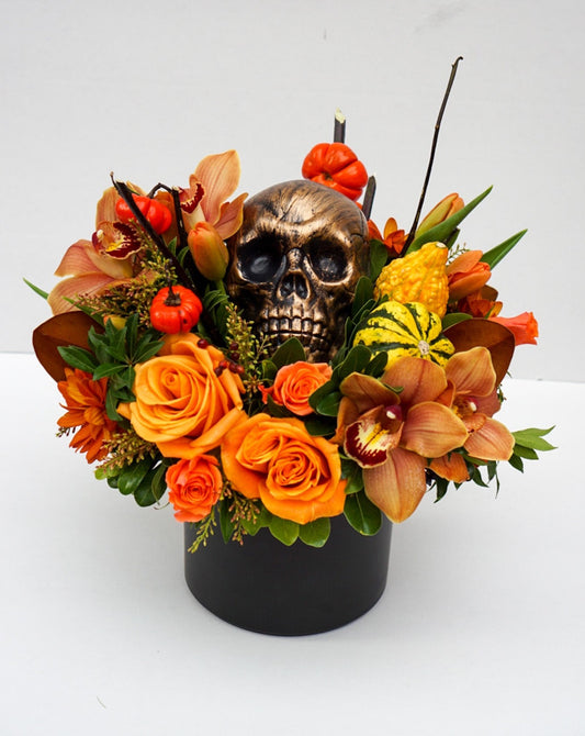 This Halloween flower arrangement is the perfect balance of scary and classy as it incorporates elements of Halloween, hence the skull, but also happy elements such as mini pumpkins, roses, orchids, celosia, etc.