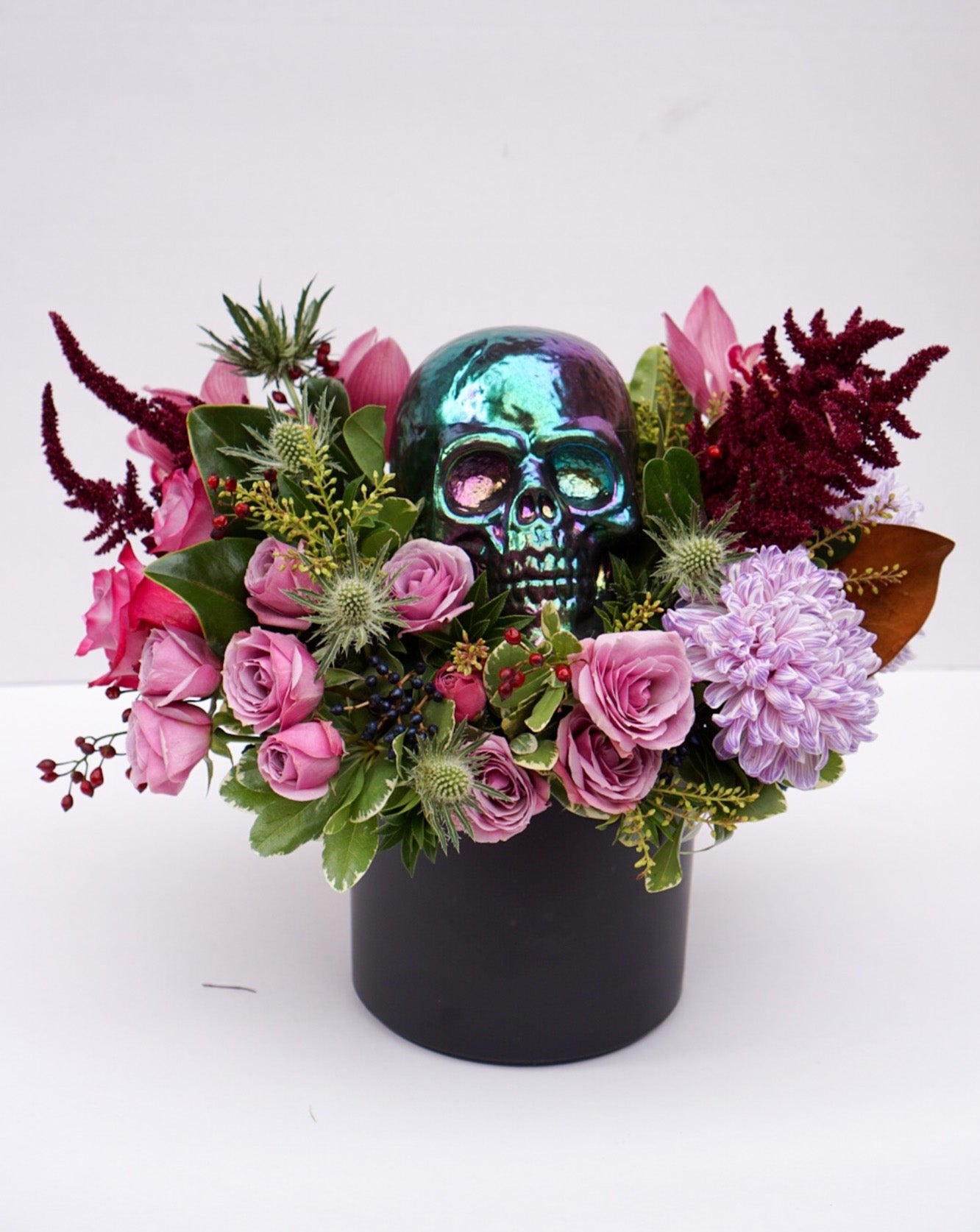 This Halloween flower arrangement is the perfect balance of scary and classy as it incorporates elements of Halloween, hence the skull, but also happy elements such as mini pumpkins, roses, orchids, celosia, etc.