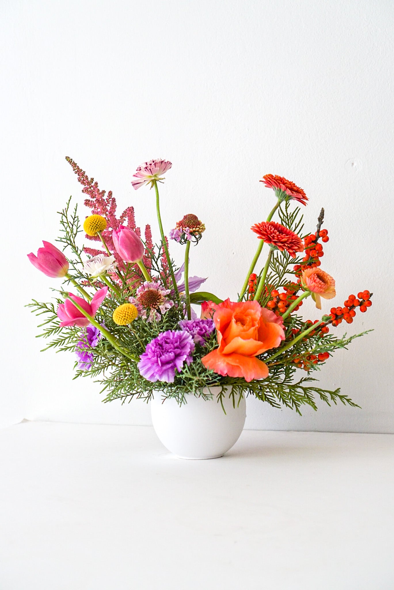 Sun Valley - An elegant modern arrangement featuring peaks of colourful and unique blooms, such as astilbe, free spirit roses, scabiosa, tulips, ilex, carnations, gerbpom. The Flower Nook. Toronto Florist