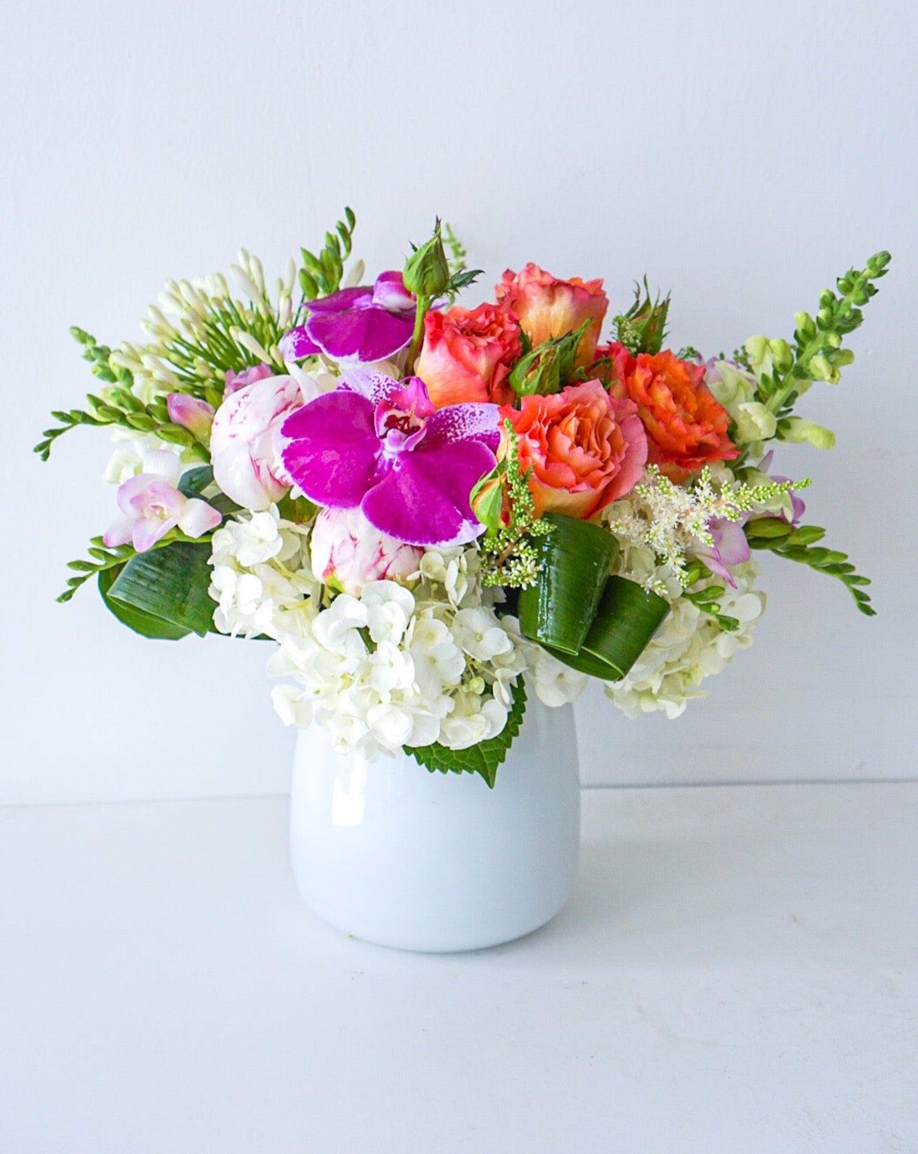 As glorious as the sunrise, this mix of hydrangeas, roses, orchids in white taper glass vase&nbsp;radiates joy. We offer same-day and next-day delivery thought out GTA and Toronto. Toronto Flower Delivery- The  Flower Nook - Toronto Florisr