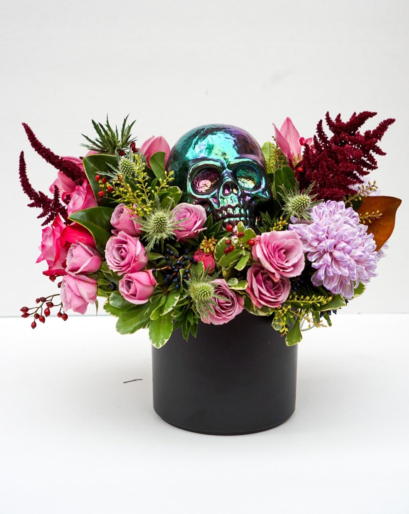 This Halloween flower arrangement is the perfect balance of scary and classy as it incorporates elements of Halloween, hence the skull, but also happy elements such as mini pumpkins, roses, orchids, celosia, etc.