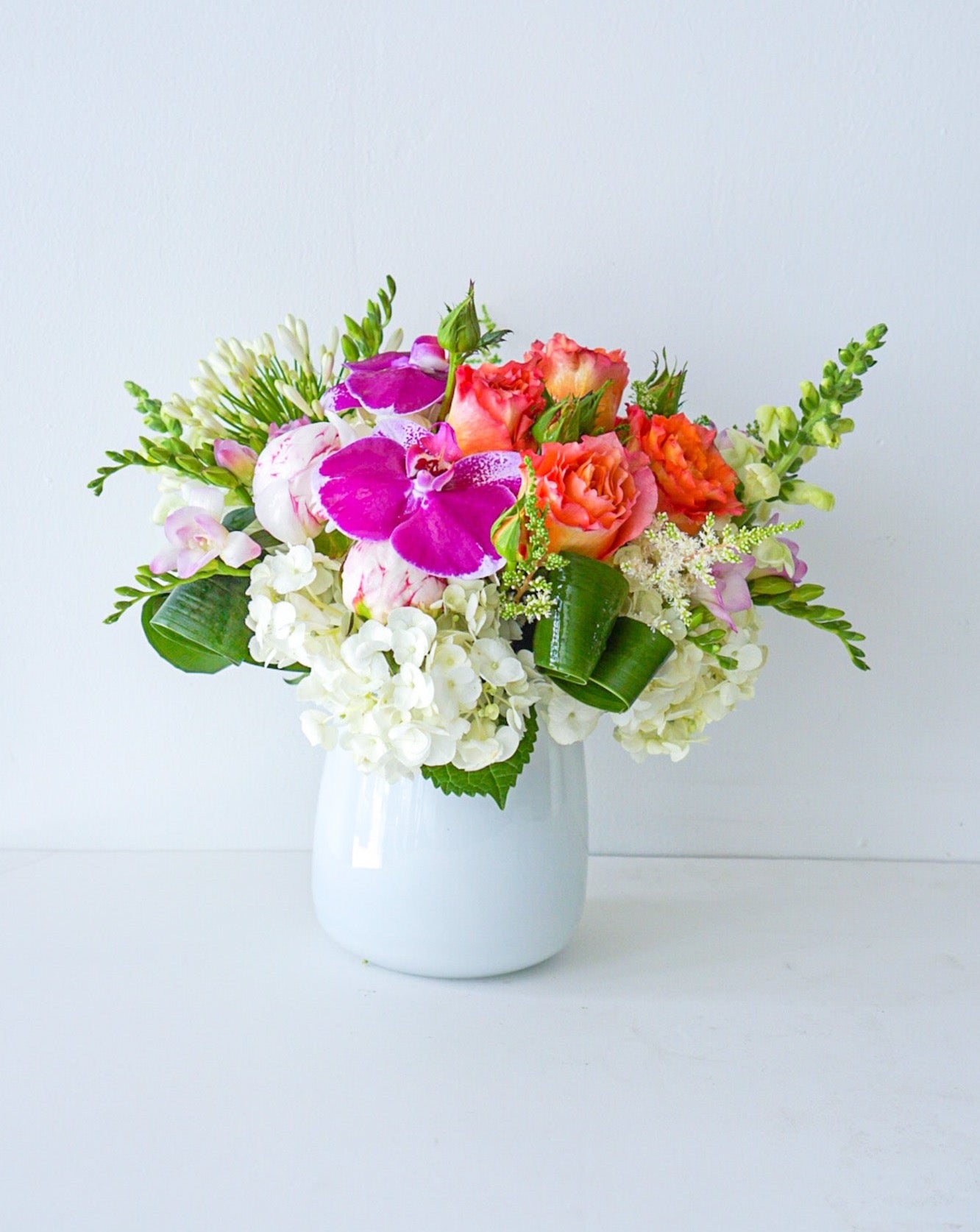 As glorious as the sunrise, this mix of hydrangeas, roses, orchids in white taper glass vase&nbsp;radiates joy. We offer same-day and next-day delivery thought out GTA and Toronto. Toronto Flower Delivery- The  Flower Nook - Toronto Florisr